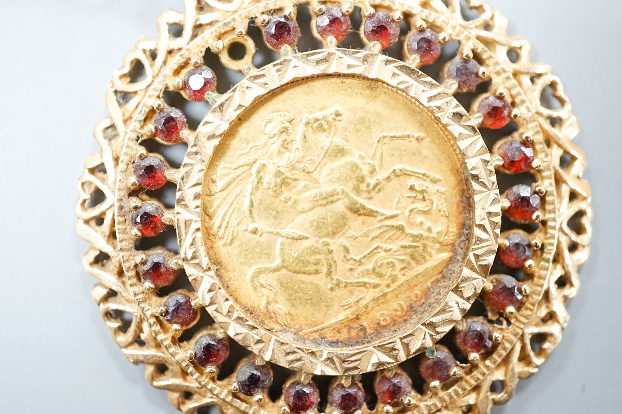 An 1892 gold sovereign, in a 9ct gold and garnet? set pendant mount on a 9ct gold chain, gross weight 29.2 grams.